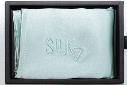 mint silk pillowcase in open black box from birds eye view