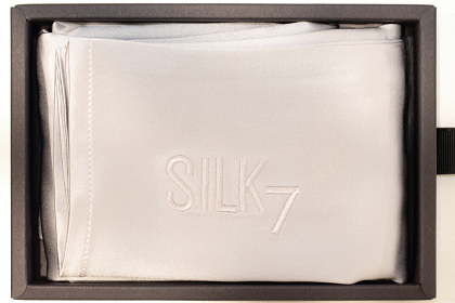 white silk pillowcase folded in black box birds eye view